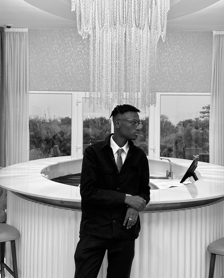 reed in a suit and tie standing in front of a bar