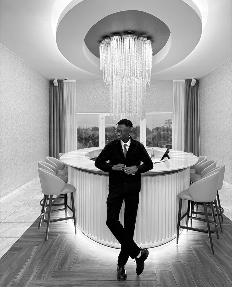 reed in a suit and tie standing infront of a bar