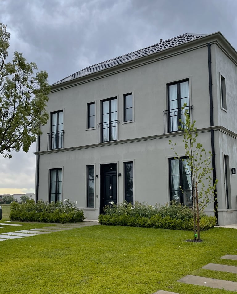 Una casa grande con un amplio césped y un árbol.