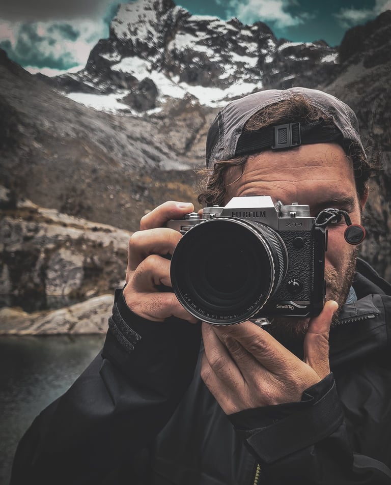 Fotografia di Marco Maggini mentre tiene in mano la macchina fotografica in montagna
