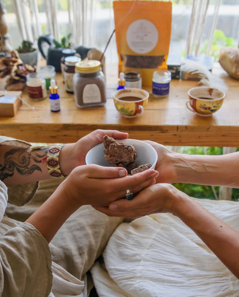 Two people holding a bowl of raw ceremonial cacao chunks during a ritual wellness ceremony.