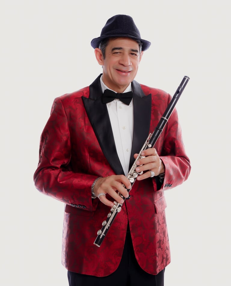 Maestro Bobby Ramiez in a tuxedo suit and hat with a flute