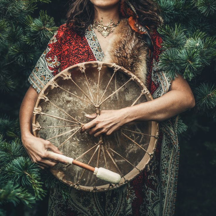 femme en tenue traditionnel, portant son tambour au niveau du coeurr