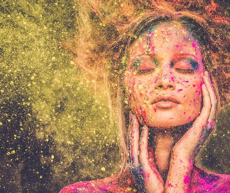 femme les yeux fermés et main autour de son visage avec paillètes dorées autour d'elle