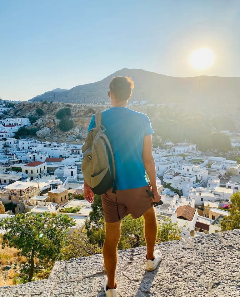 a man watching down on lindos village in rhodes