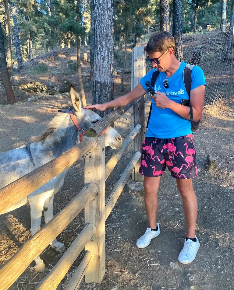 a man with looneytravels t shirt and a donkey