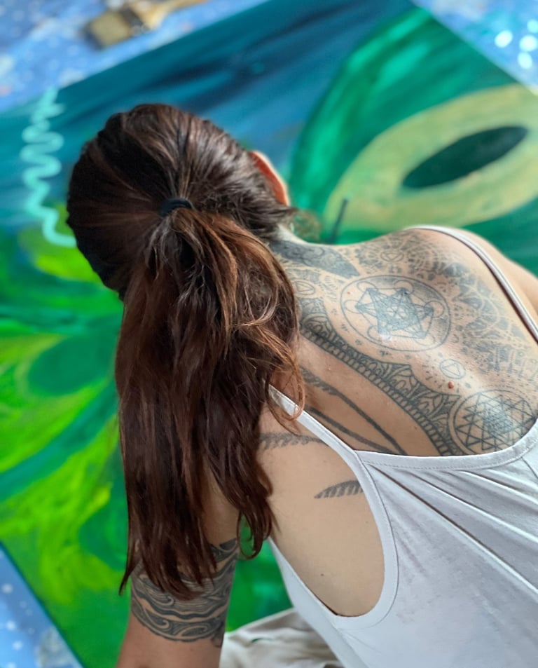 a woman painting with sacred geometry tattoes