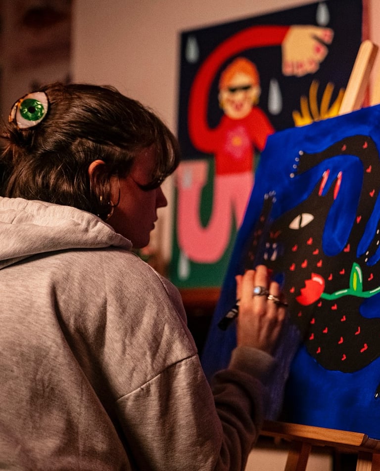 a woman is painting a picture of a cat