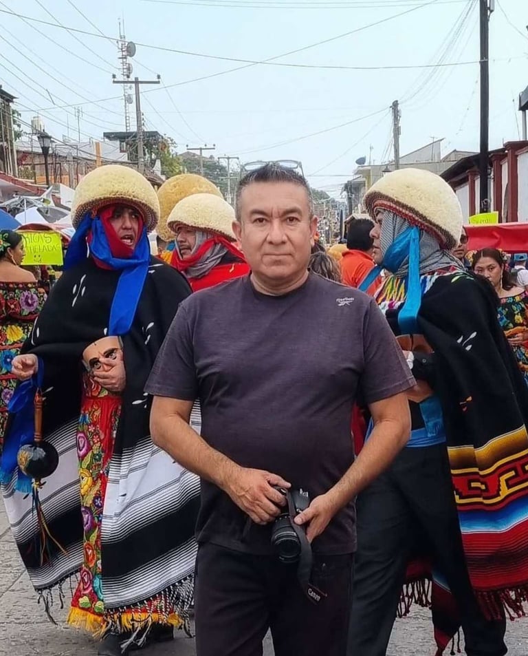 Un fotógrafo se encuentra frente a danzantes tradicionales Parachicos con trajes festivos durante un