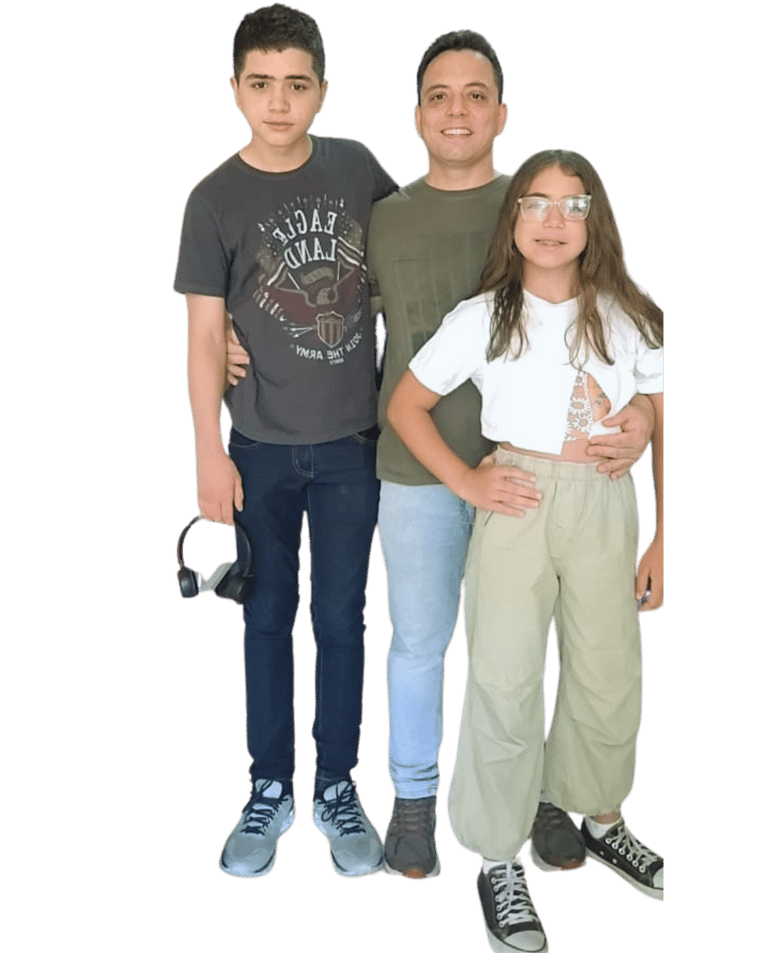 Alan Ochotorena, pai atípico e autista, abraçado com seus filhos adolescentes. Família sorrindo.