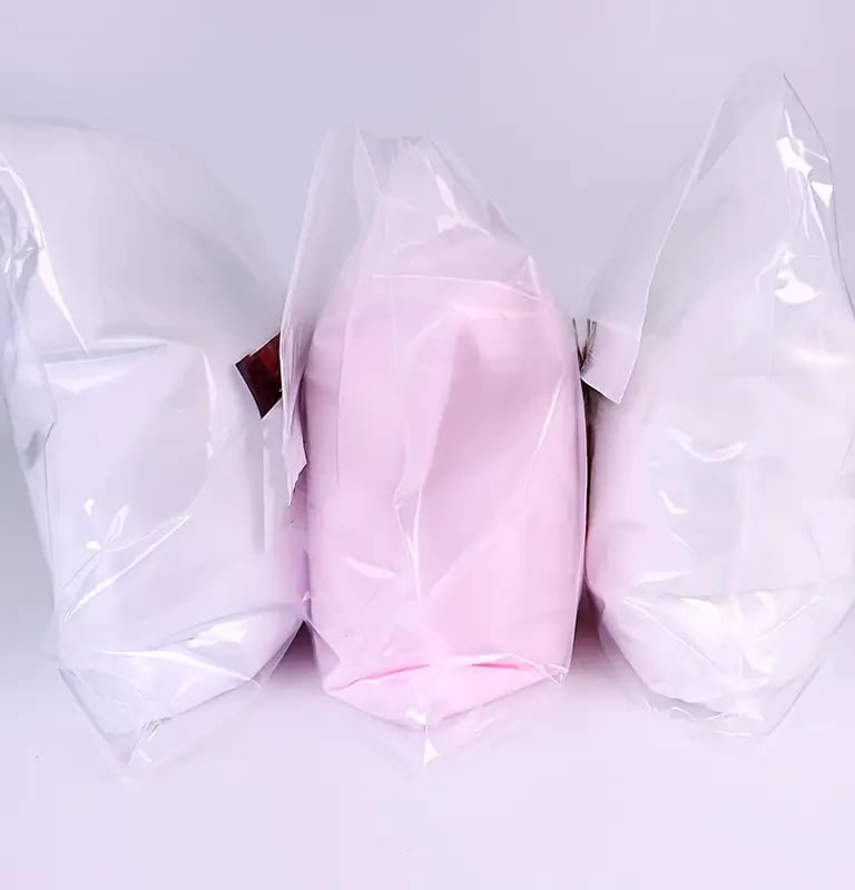 three bags of white and pink colored pillows