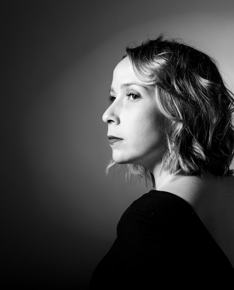 Photo en noir et blanc d'une femme de profil sur fond noir avec halo