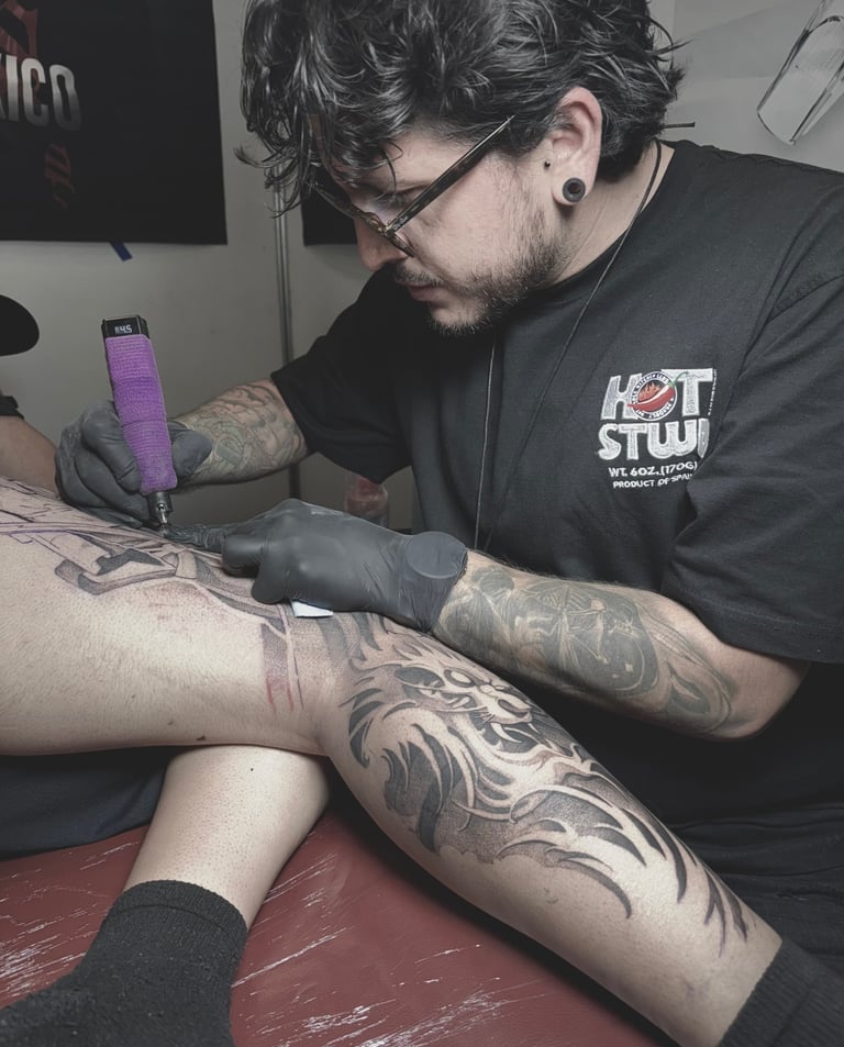 a man is getting a tattoo on his leg