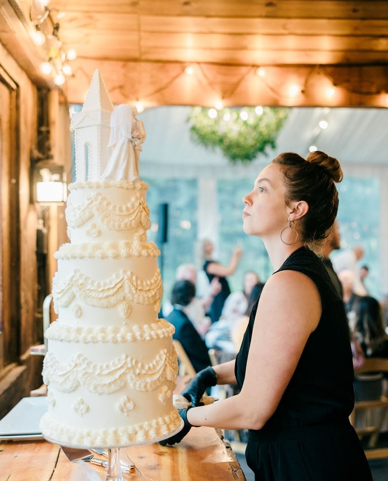 Business owner and baker putting finishing touches on a luxury vintage wedding cake
