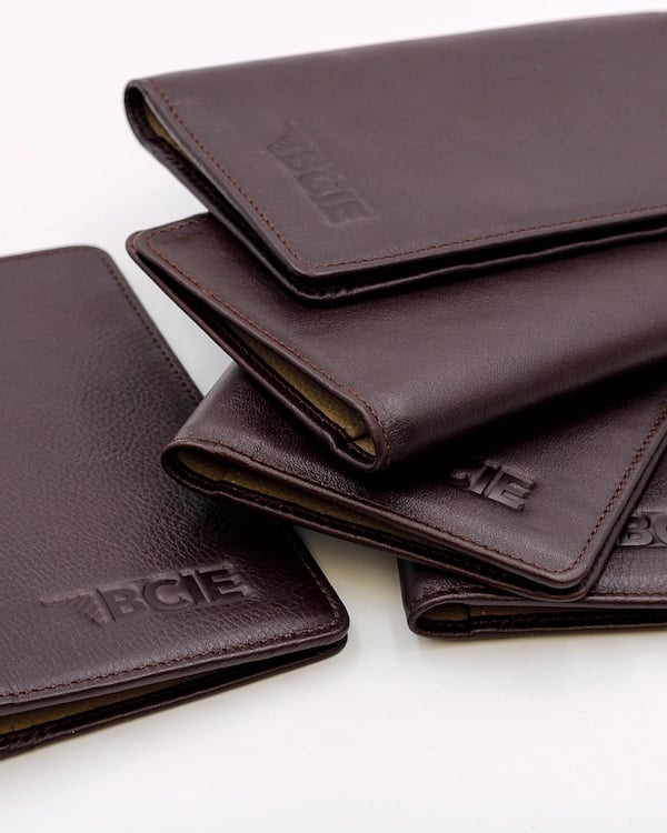 a group of four leather wallets with the word's name on it