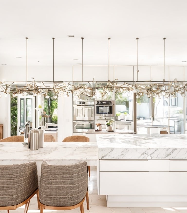uma cozinha com bancada de mármore e cadeiras
