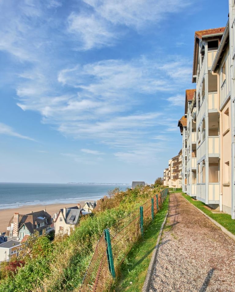 Luxe appartementen aan het strand met houten balkons die uitkijken op een zandstrand en de blauwe