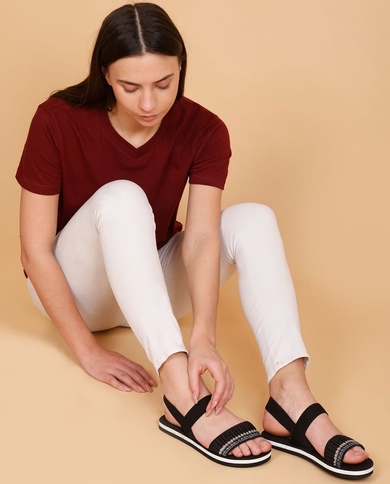 a woman looking her embroided black sandal