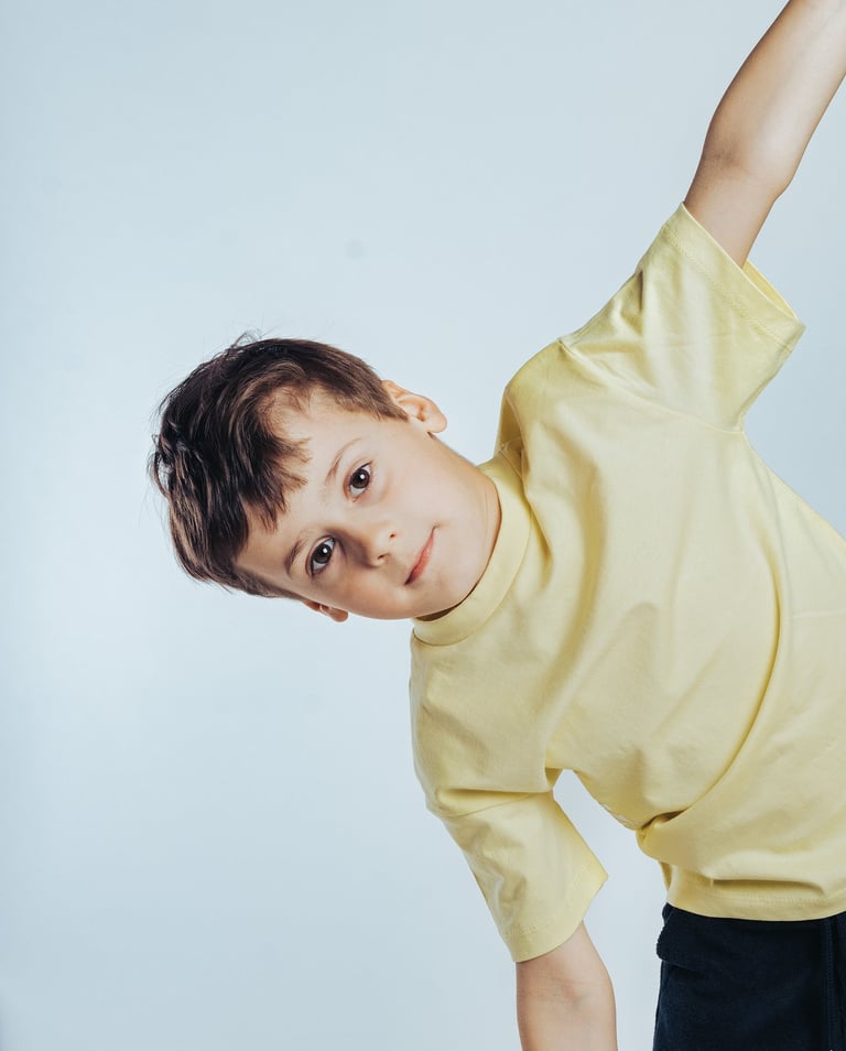 portrait of a young boy in a yellow shirt and black pants