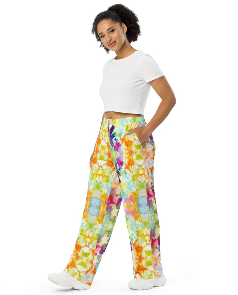 a woman in a white crop top and colorful floral pants