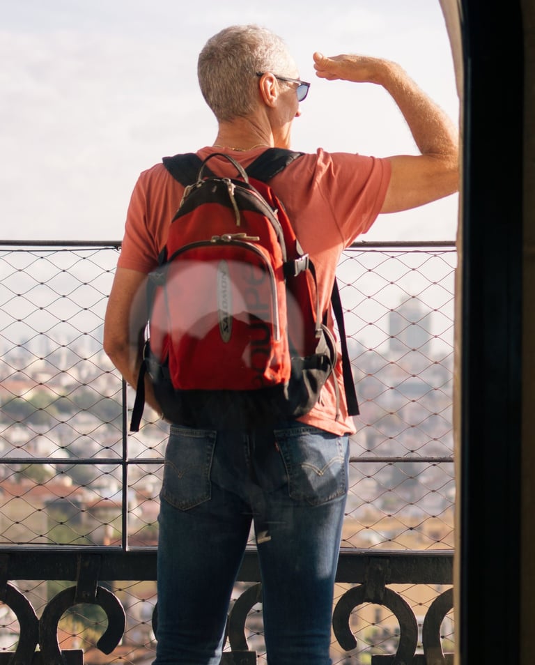 Uomo con zaino guarda il panorama durante un viaggio in autonomia.