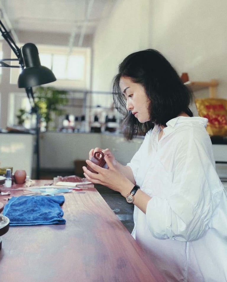 Artisan Kuai Yunhan examining a teapot