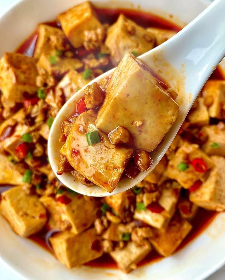 a spoonful of mapo Tofu with a spoon in it