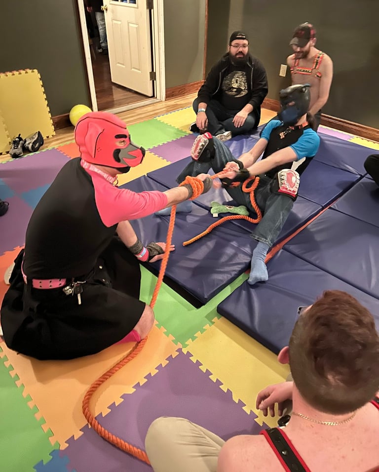 a group both in and out of pup hoods playing tug of war.