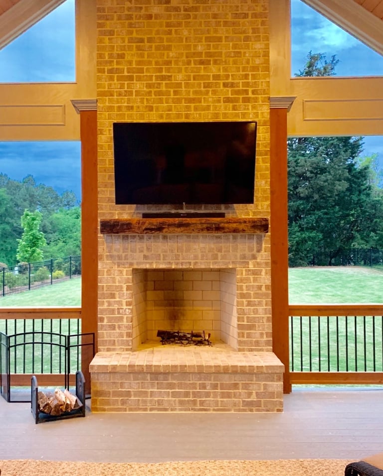 outdoor tv and soundbar mounted on a brick fireplace
