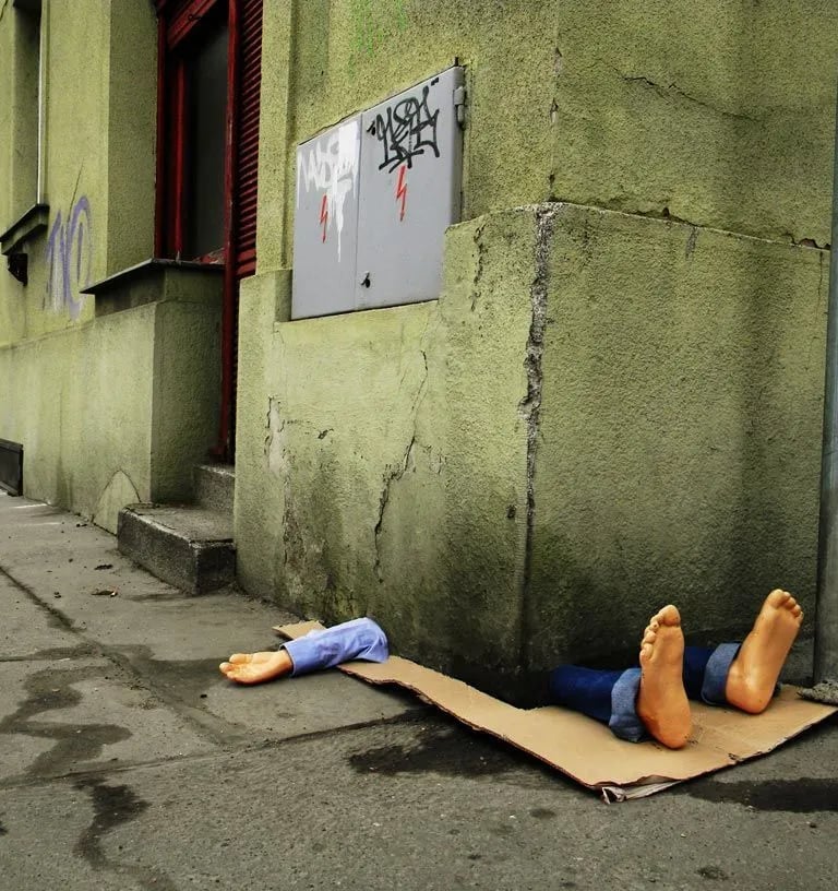 Em Praga, Fra.Biancoshock criou uma intervenção impactante que retrata um morador de rua sendo esmag