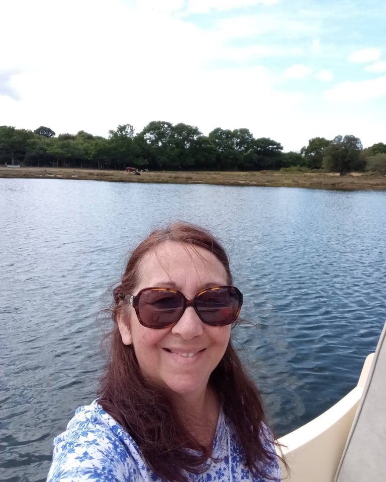 Artist in her boat on the river Beaulie, UK