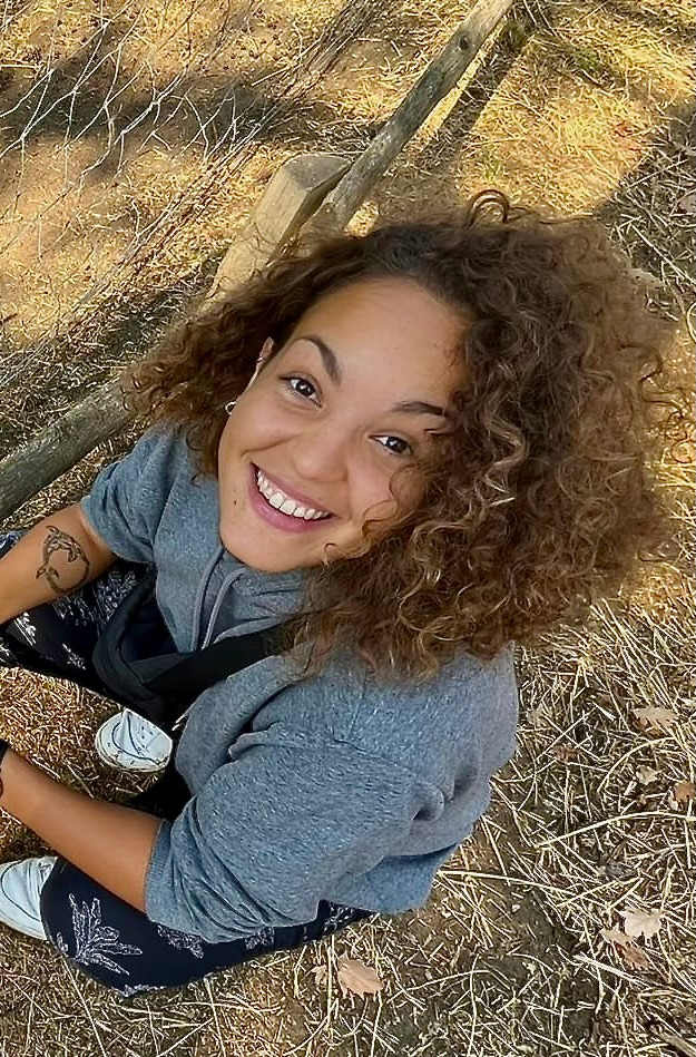 a woman smiling sitting on the ground