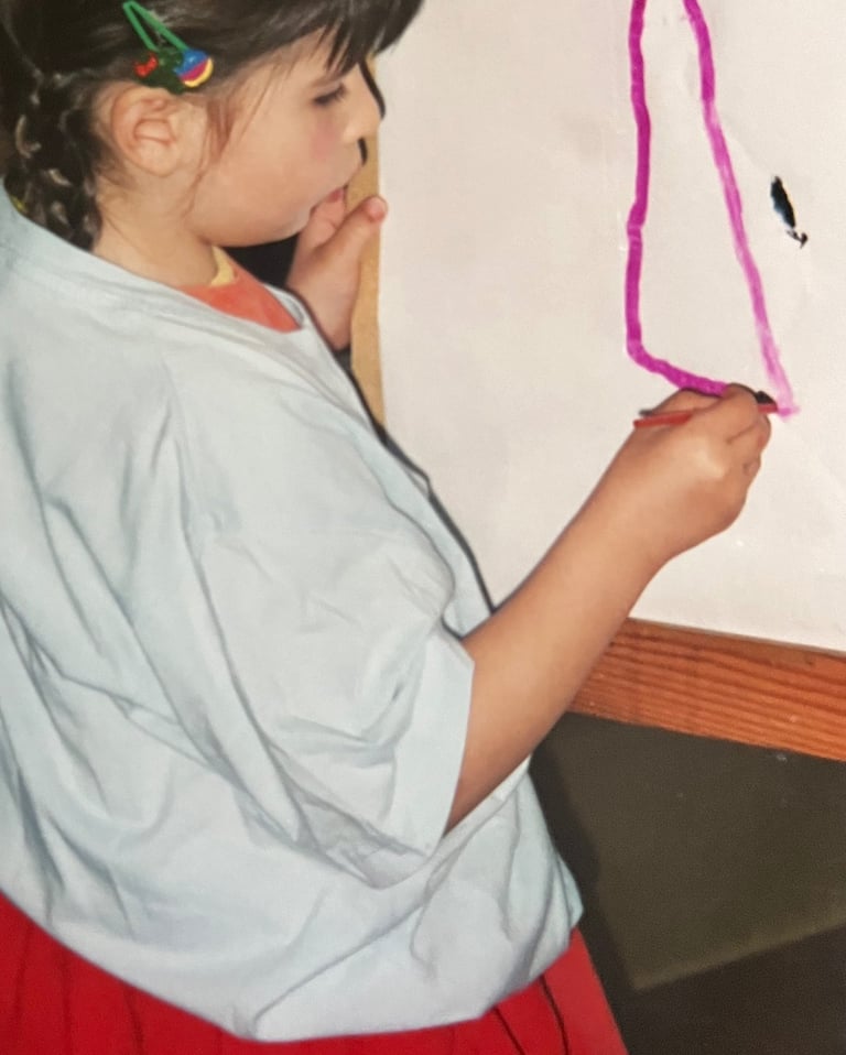 a young girl is holding a piece of paper and a pencil