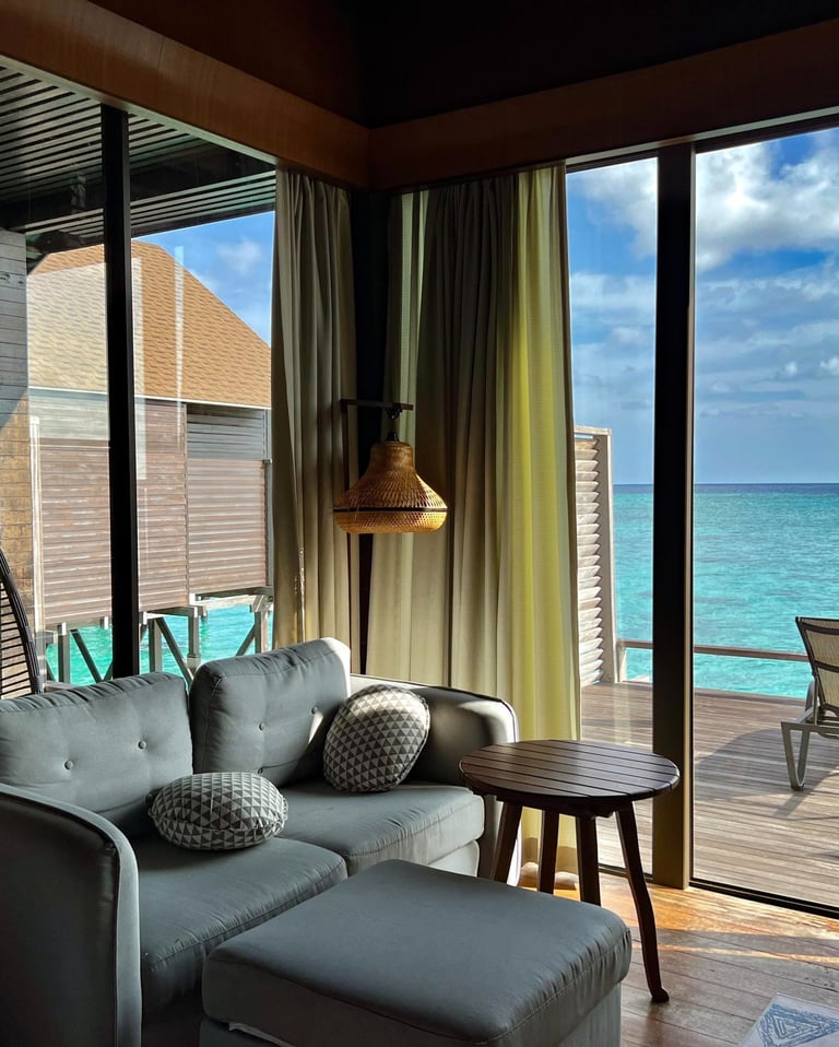 Sofa and living area inside a water chalet at Lankayan Island Resort.