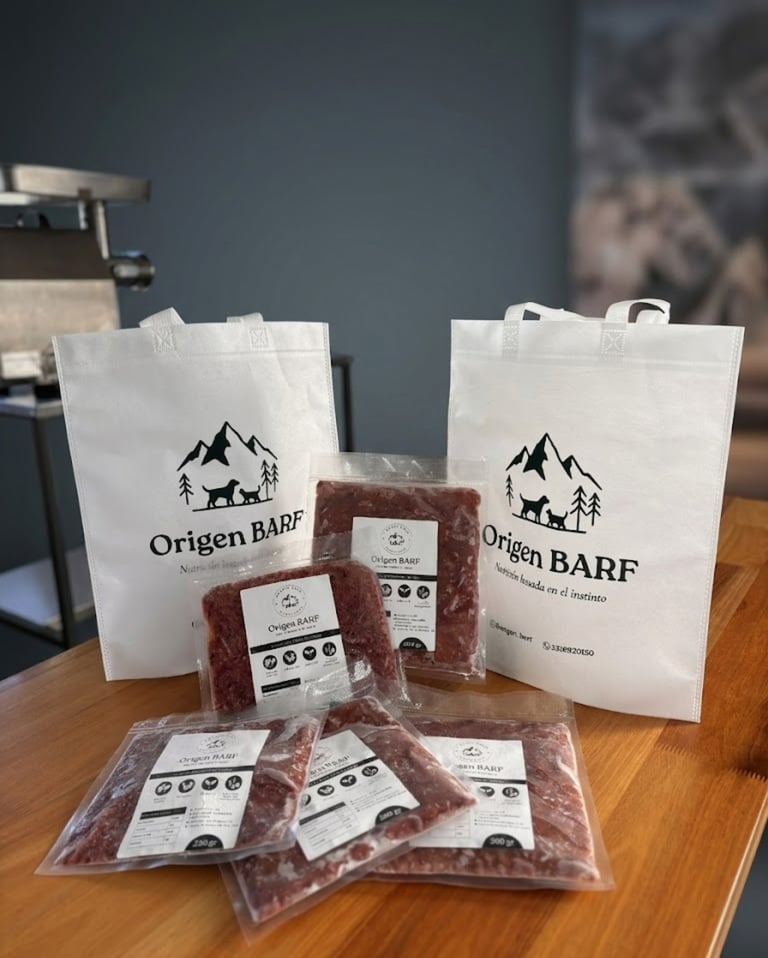Viandas con alimento barf listas para servir junto a las bolsas de la marca origen barf
