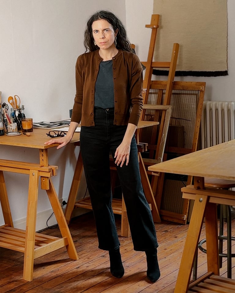 Portrait en pied et en couleurs de l'artiste Sabine Segura dans son atelier.