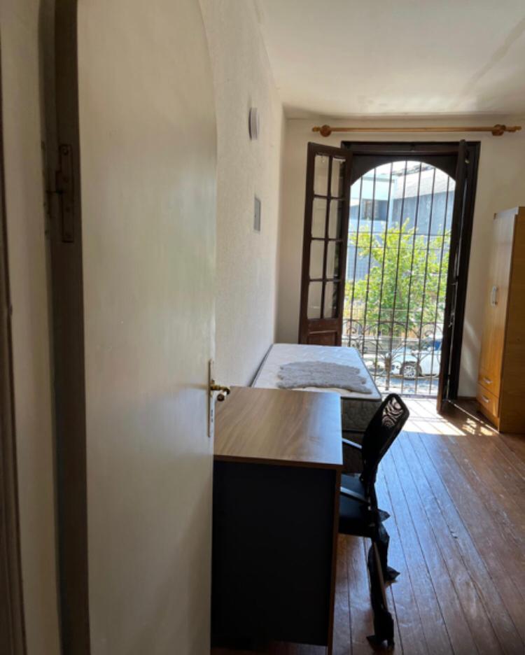 Habitación con escritorio mesa de luz y ventana