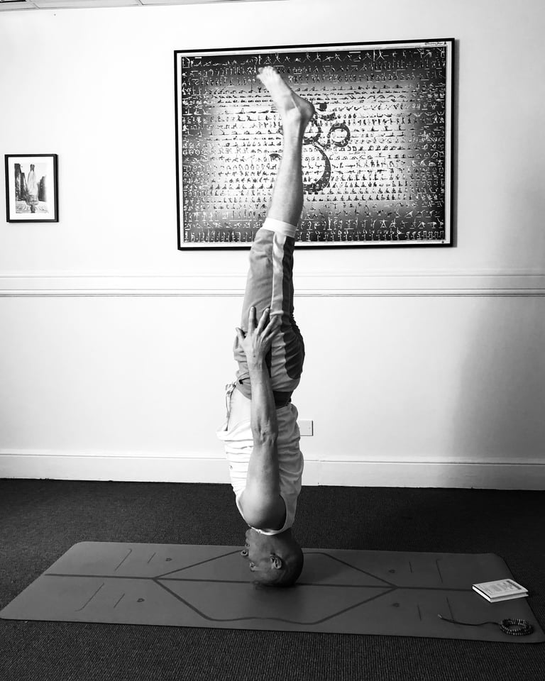 a man doing a headstand yoga pose