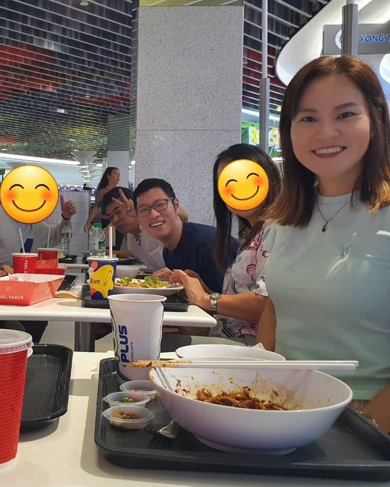 a group of japanese people sitting at a table with smiley faces