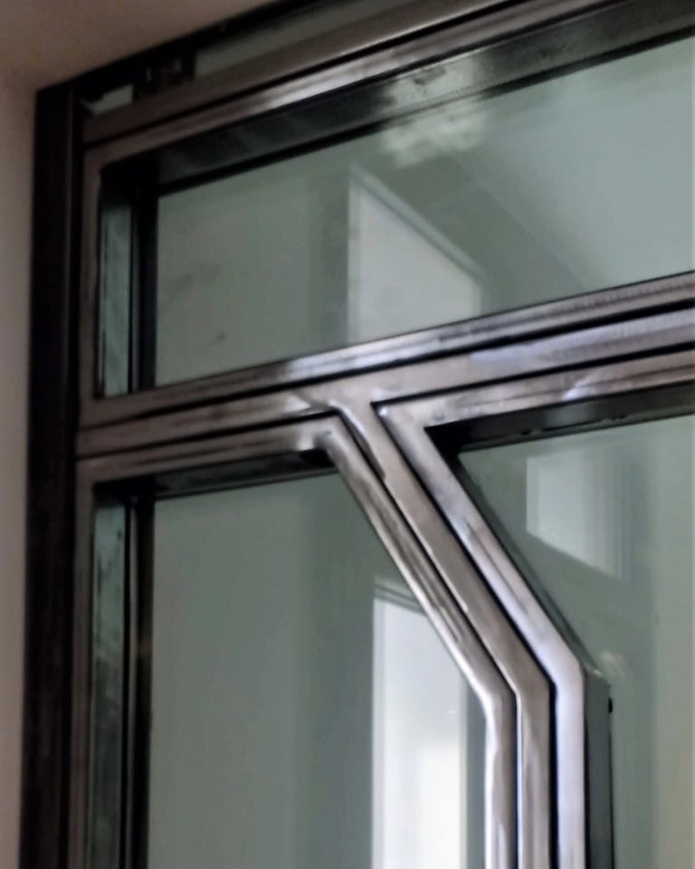 A glass door with custom-made raw steel elements