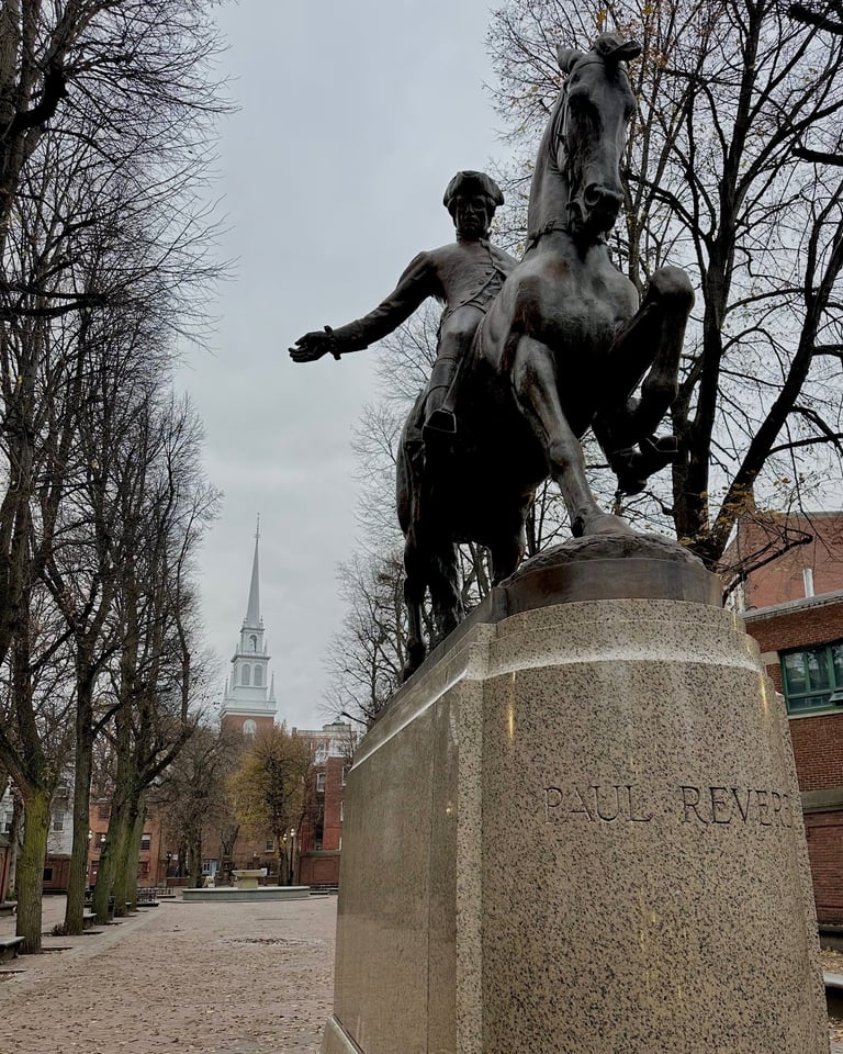 a statue of Paul revere in front of Old North Church in Boston 
