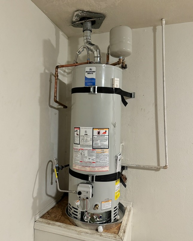 A Bradford White natural gas water heater installed with seismic straps and an expansion tank.