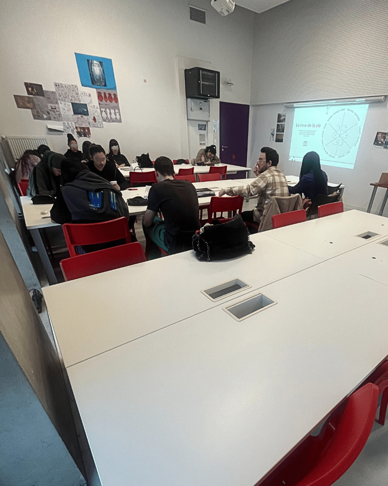 Students collaborate in a modern classroom setting with a projector screen showing a diagram.