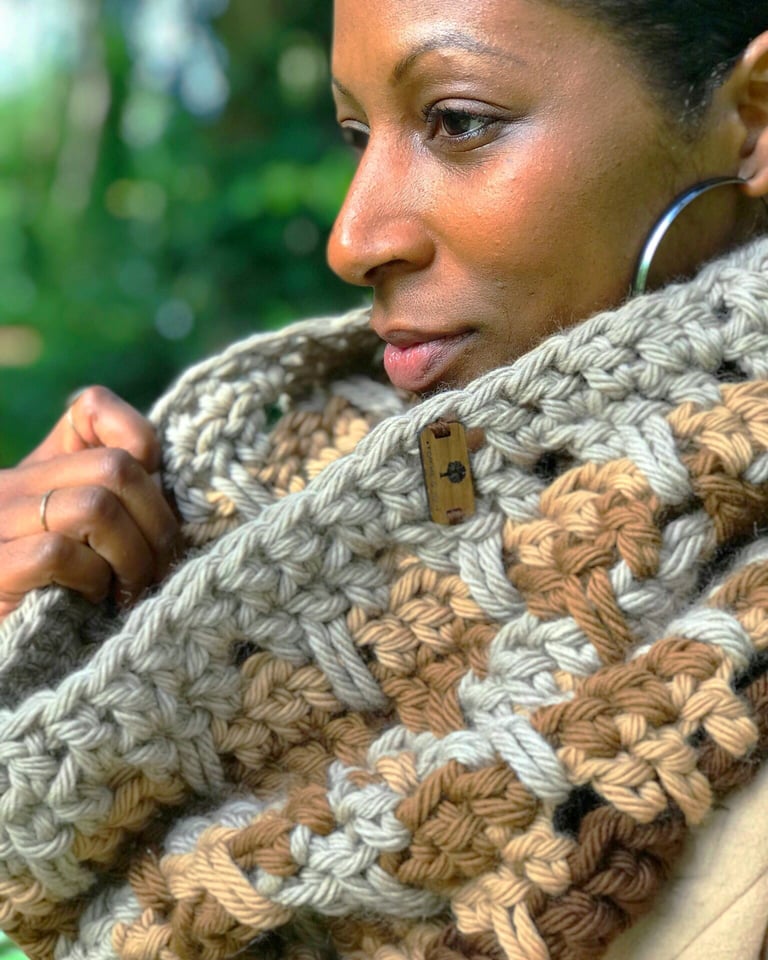 A woman wearing a chunky crochet cowl around her neck