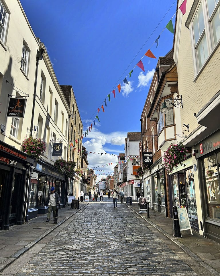 Rue pietonne pavée bordée de petits magasins 