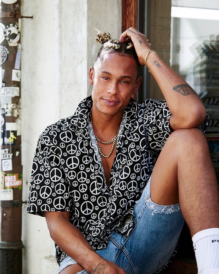 a man sitting on a ledge with a peace sign