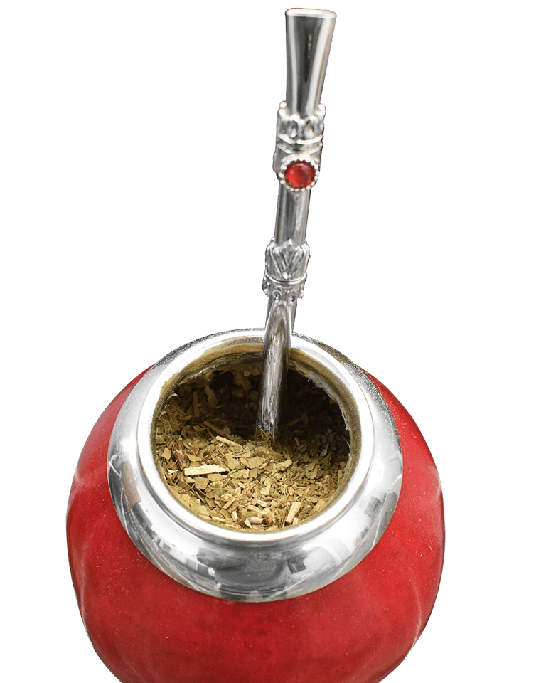 Close-up of a vibrant red calabash gourd filled with yerba mate tea and a decorative silver bombilla, set against a dark