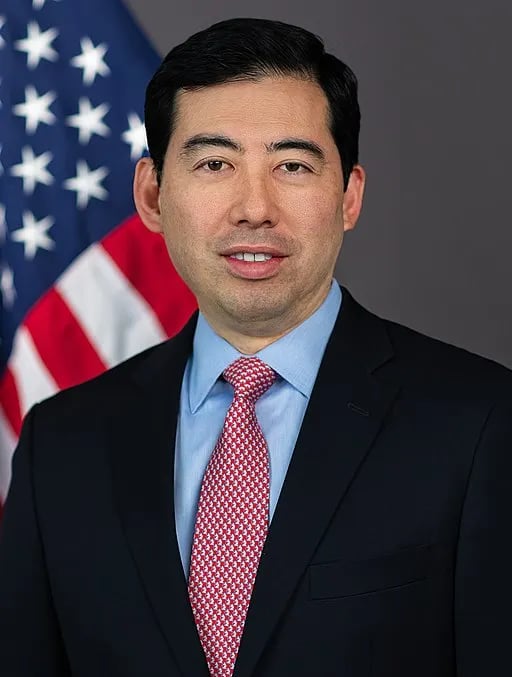 a man in a suit and tie with a flag