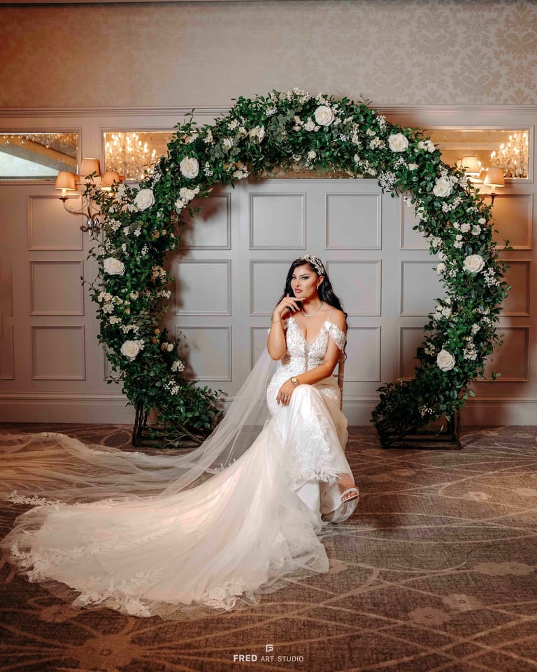 Bride posing under floral arch in wedding gown – Oxford wedding photography by Fred Art Studio