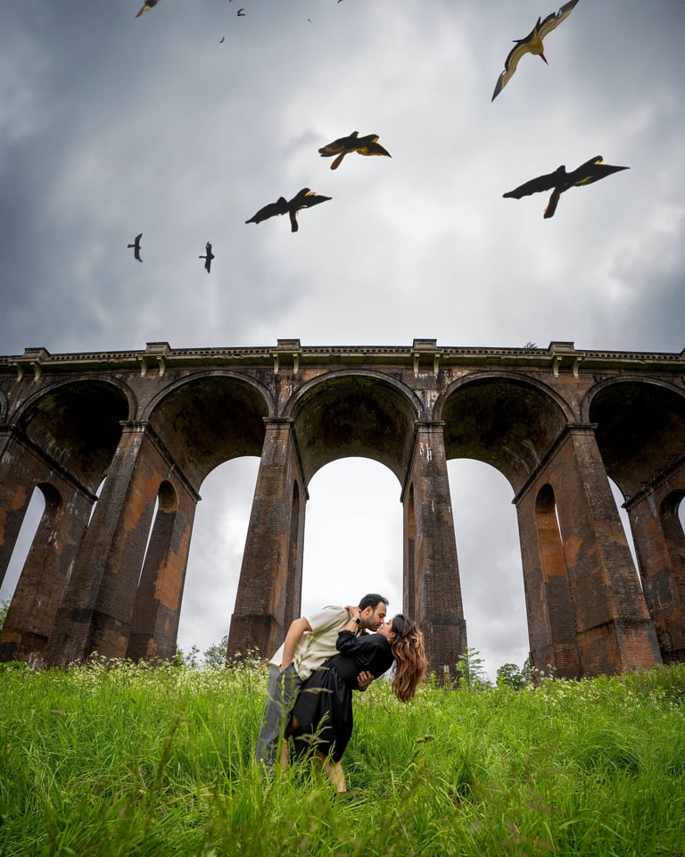 Romantic couple under bridge with birds in sky – cinematic outdoor photography by Fred Art Studio